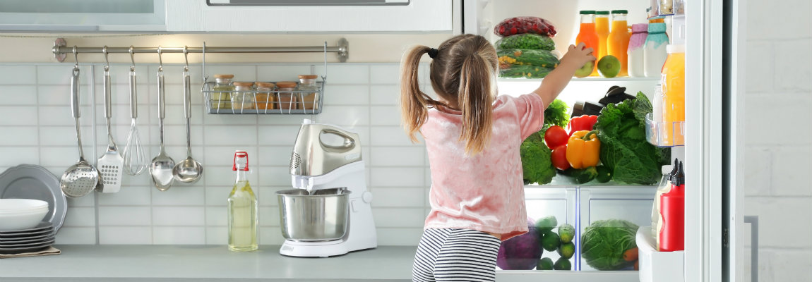 Mädchen am Kühlschrank. Das Bild linkt auf den Beitrag zum Thema Nährstoffe.