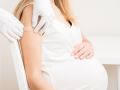 Eine schwangere Frau bekommt nach der Impfung ein Pflaster.