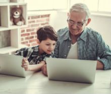 Großvater und Kind informieren sich am Computer
