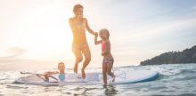 Familie im Wasser auf Surfboard