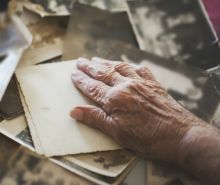Hand einer älteren Person auf alten Fotos